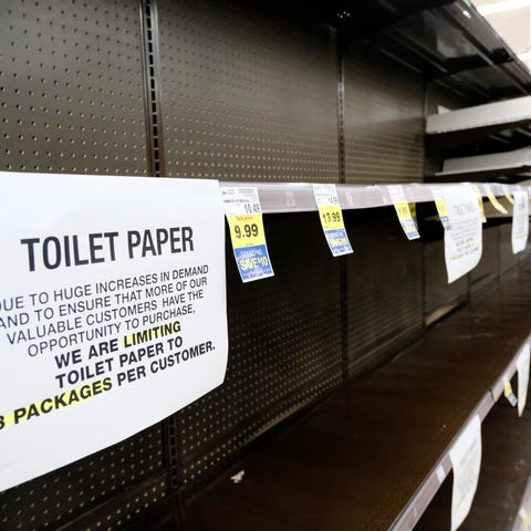 Shelves are picked bare of toilet paper at a groce