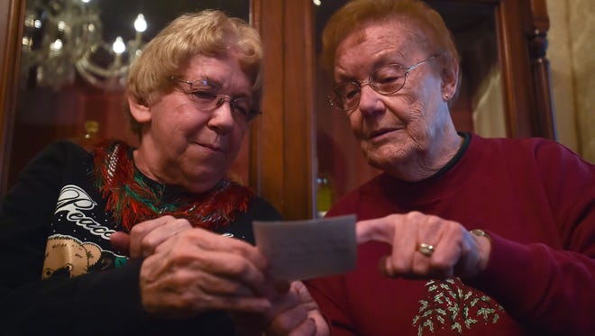 Doris Large, left, looks at a photograph with Ruth Gembe during the Historical Holiday Chat inside Waynesboro's Historical Society's Oller House on Saturday, Dec. 12, 2015, in Waynesboro, Pa. Participants brought in old pictures of the holidays and spoke about their Christmas memories.