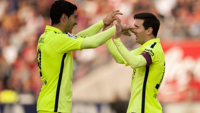 Barcelona's Lionel Messi celebrates his goal with teammate Luis Suarez during a Spanish La Liga soccer match between Granada and FC Barcelona.