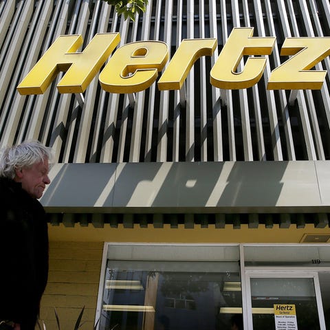 A person walks by a Hertz rental car office in 201