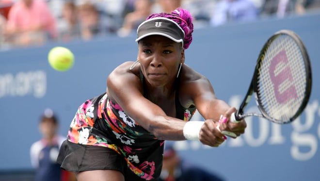 FILE - Venus Williams  returns a shot to Kirsten Flipkens  on Aug. 23 during the 2013 U.S. Open in New York.