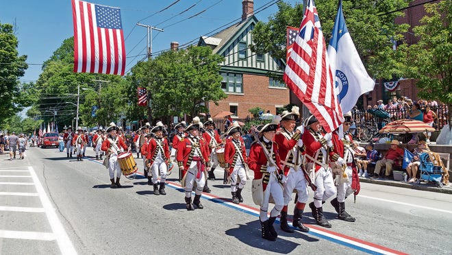 Marchers follow the red, white and blue stripes painted in the center of town during the Bristol Fourth of July Parade in 2016.