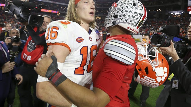 Clemson quarterback Trevor Lawrence, left, and Ohio State quarterback Justin Fields meet after the Fiesta Bowl NCAA college football playoff semifinal Saturday, Dec. 28, 2019, in Glendale, Ariz.