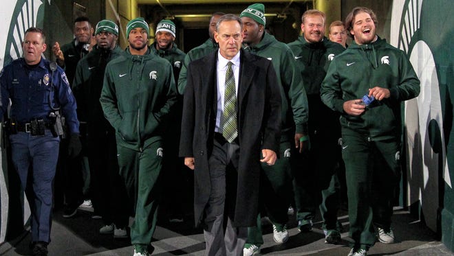Michigan State football coach Mark Dantonio leads his team onto the field prior to a game against the Ohio State Buckeyes at Spartan Stadium.