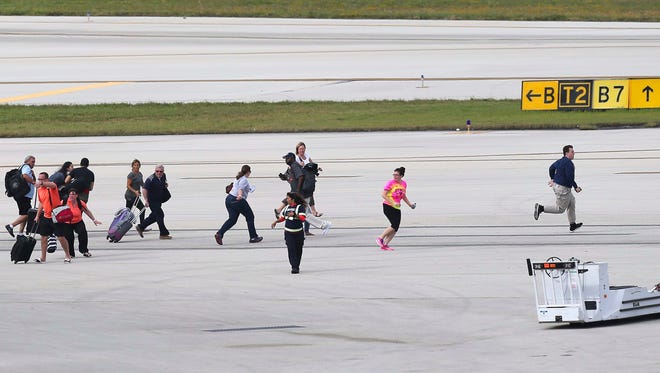 Passengers run for safety on the tarmac at Fort Lauderdale-Hollywood International Airport following the shooting Friday.