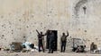 Iraqi forces gesture as they stand outside a building