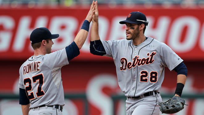 Detroit Tigers shortstop Andrew Romine (27) high-fives J.D. Martinez (28).