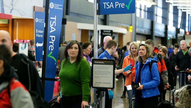 FILE - In this March 17, 2016, file photo, travelers authorized to use the Transportation Security Administration's PreCheck expedited security line at Seattle-Tacoma International Airport in Seattle have their documents checked by TSA workers. Massive lines at airports have now led to a backlog of people trying to enroll in trusted traveler programs. Waits to join PreCheck or Global Entry are months long in some cities. (AP Photo/Ted S. Warren, File)