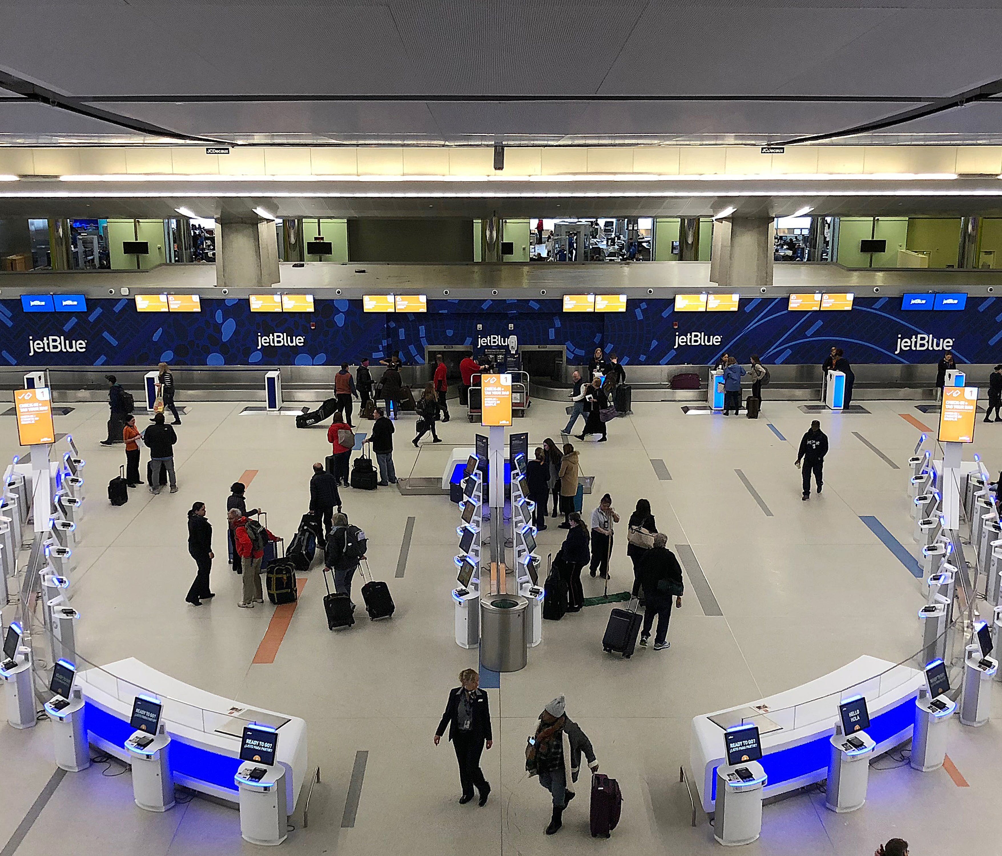 Passengers arrive at the JetBlue Airways' self-service lobby in Terminal C at Logan Airport in Boston on March 22, 2018.