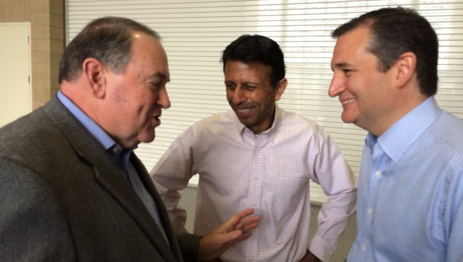 Mike Huckabee, left, Bobby Jindal, center, and Ted Cruz, right, share hunting stories backstage at the Growth and Opportunity Party in Des Moines on Saturday.