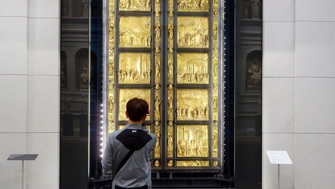 A visitor admires Lorenzo Ghiberti’s Gates of Paradise in Florence's newly refurbished Duomo Museum.