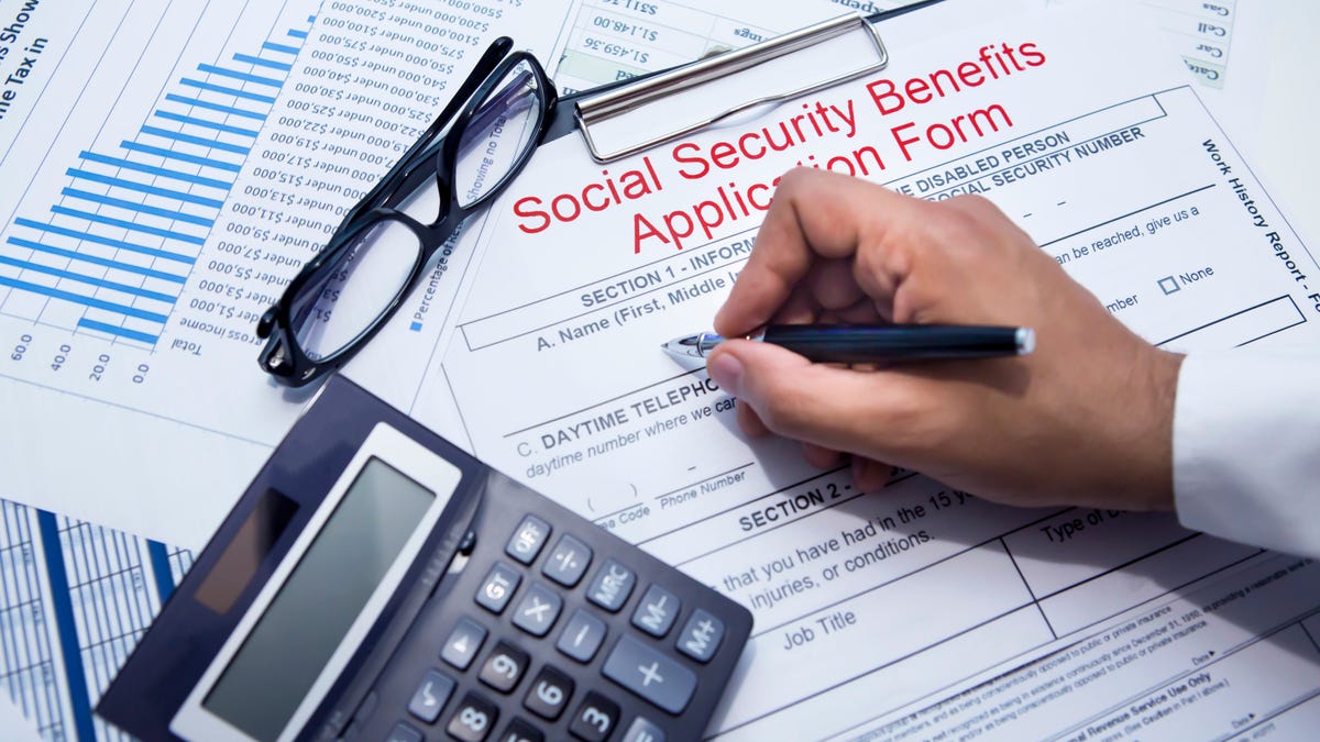 A person filling out a Social Security benefits application form.