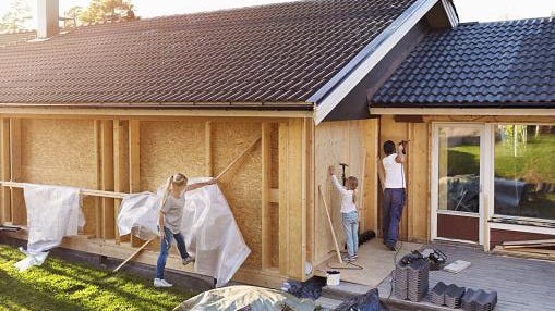 Family using hammer on walls of house being renovated