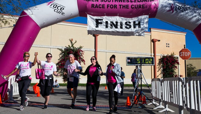 Lela Fishman, from left, Kaki Scala, Tom Nigolian, Erin Jensen, and Katya Richie hold hands as they cross the finish line together during the 12th Annual Komen Southwest Florida Race for the Cure¨ at Coconut Point mall in Estero on Saturday, March 3, 2018. The group of strangers met each other while walking the course and decided to help each other finish the race. 