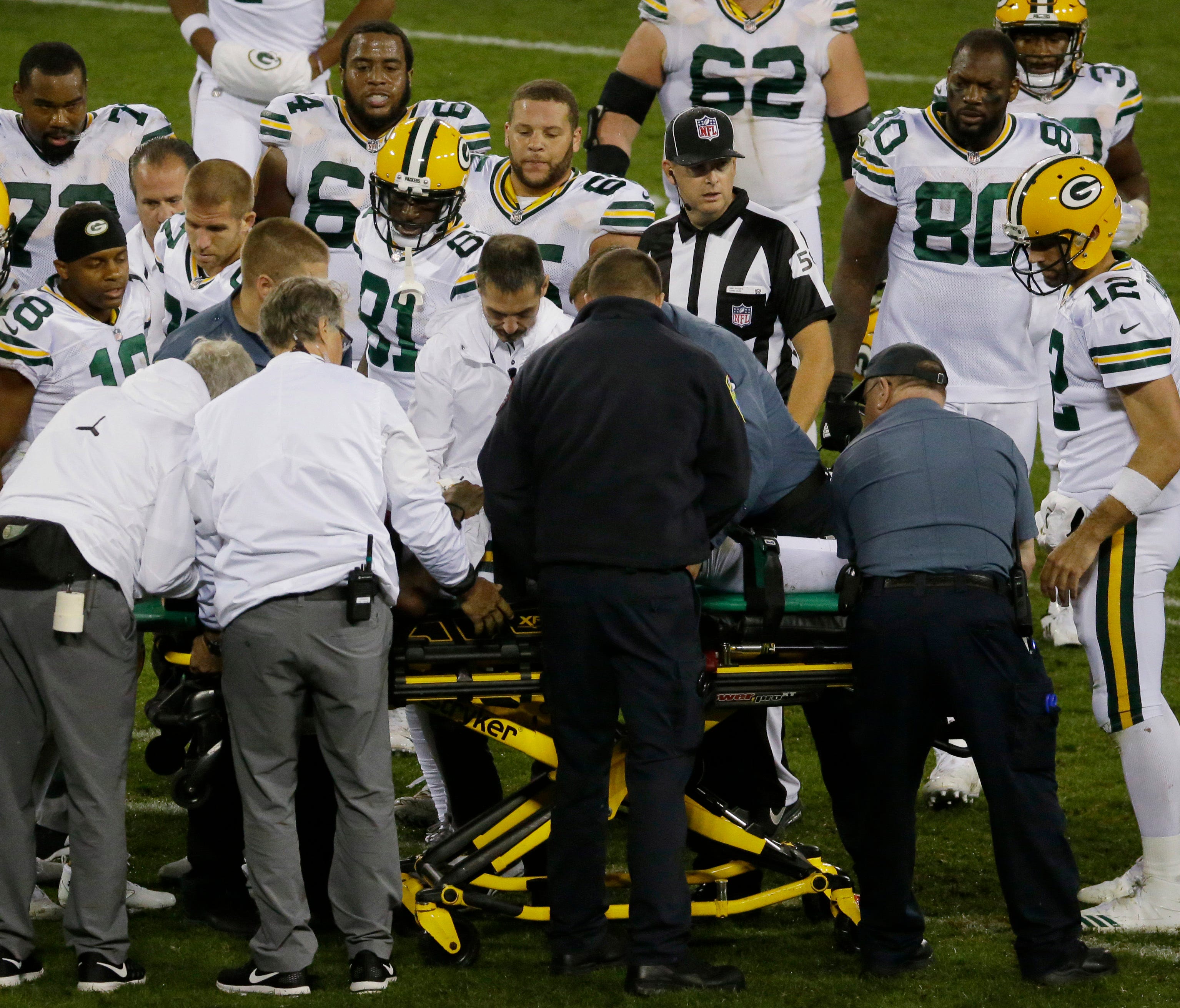 Teammates gather around Green Bay Packers wide receiver Davante Adams as he is taken from the field on a stretcher after being drilled by Chicago Bears inside linebacker Danny Trevathan  during the third  quarter at Lambeau Field.