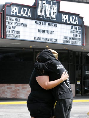 Jessenia Camacho (left) and Sheina Almaguer, fans of singer Christina Grimmie, embrace outside the Plaza Live on June 11, 2016, in Orlando. Both attended Grimmie's final concert the night before, where the singer was killed in a post-show meet-and-greet.