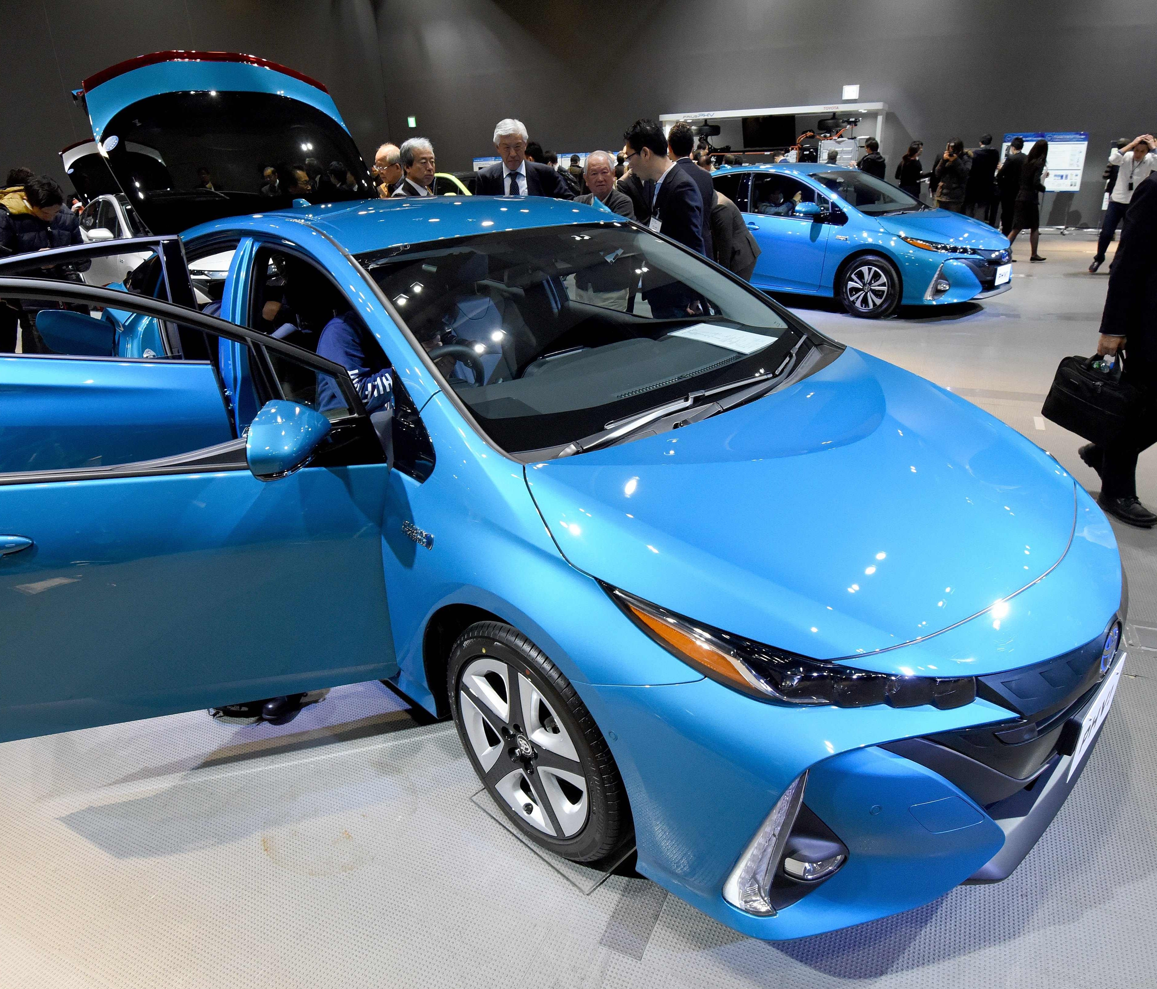 Journalists look at the redesigned Toyota Motor Prius plug-in hybrid vehicle, one of the automaker's electrified models