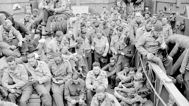 U.S. serviceman attend a Protestant service aboard a landing craft before the D-Day invasion on the coast of France, June 5, 1944.