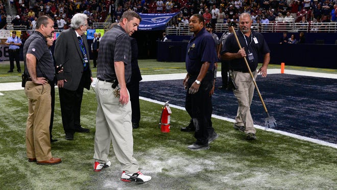 Stadium workers at St. Louis' Edward Jones Dome extinguish a turf fire Sunday.