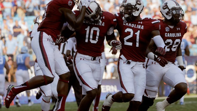 South Carolina's Skai Moore (10) celebrates with teammates after his interception against North Carolina in the first half of an NCAA college football game in Charlotte, N.C., Thursday, Sept. 3, 2015. (AP Photo/Chuck Burton)