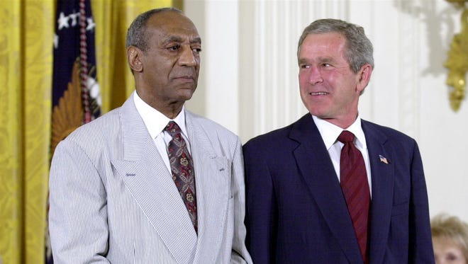 In 2003, President Bush stands with comedian Bill Cosby during the announcement of Cosby’s Presidential Medal of Freedom at the White House.