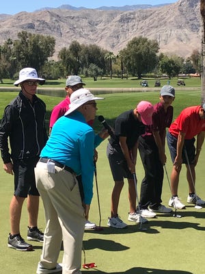 Noted putting instructor Dr. Craig Farnsworth demonstrates putting practices with members of The First Tee of the Coachella Valley at the First Tee tournament Friday.