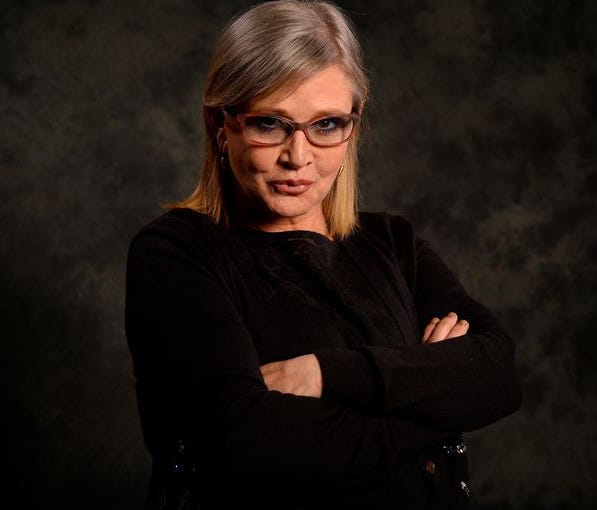 Carrie Fisher poses for a photo while promoting Star Wars: The Force Awakens
