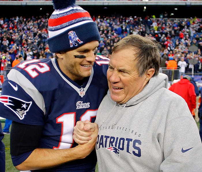 Dec 14, 2014; Foxborough, MA, USA; New England Patriots quarterback Tom Brady (12) celebrates with head coach Bill Belichick (R) after clinching the AFC East title with a 41-13 win over the Miami Dolphins at Gillette Stadium. Mandatory Credit: Winslo