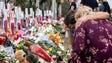 People visit a makeshift memorial in front of the Marjory
