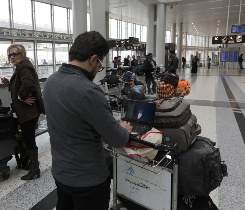 A Syrian passenger traveling to the United States through Amman, Jordan, types on his laptop before entering Beirut International Airport's departure lounge in Lebanon on March 22, 2017.