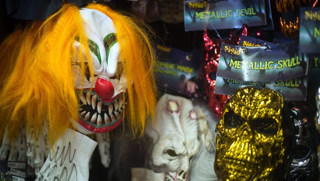 This file photo taken on October 21, 2013 shows, Halloween masks on a wall at Spirit Halloween costume store in Easton, Maryland. 
A series of creepy clown sightings across the United States has caused a wave of hysteria, forcing police and schools to scramble to contain spreading jitters, and even the White House to weigh in.