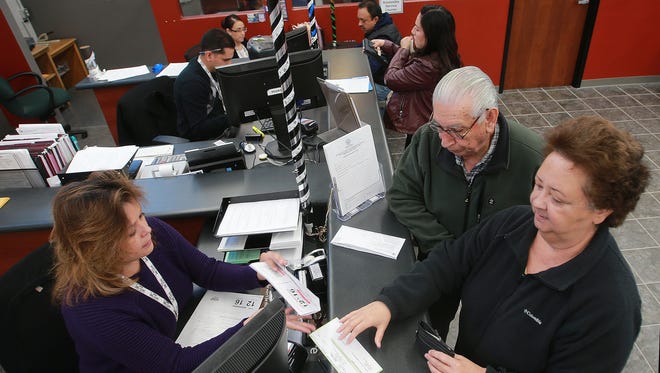 Vehicle Registration Clerk Ruth Sierra, left, assisted Gloria and Arturo Chacon who were renewing their vehicle registration Thursday at the El Paso County Tax Assessor-Collector office at 301 Manny Martinez.