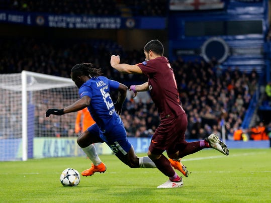 Barcelona's Luis Suarez, right, and Chelsea's Victor Moses fight for the ball during the Champions League, round of 16, first-leg soccer match between Chelsea and Barcelona at Stamford Bridge stadium, Tuesday, Feb. 20, 2018. (AP Photo/Frank Augstein)