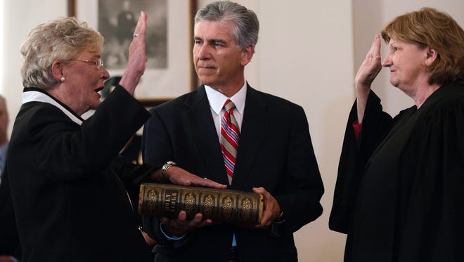 Alabama's acting chief Supreme Court justice, Lyn Stuart, right, swears in Lt. Gov. Kay Ivey on April 10, 2017, as Alabama's 54th governor and its first Republican woman. The Rev. Jay Wolf, senior pastor of First Baptist Church in Montgomery, Ala., holds the Bible for his congregant in the ceremony in the Alabama Capitol's Old Senate Chamber in Montgomery.