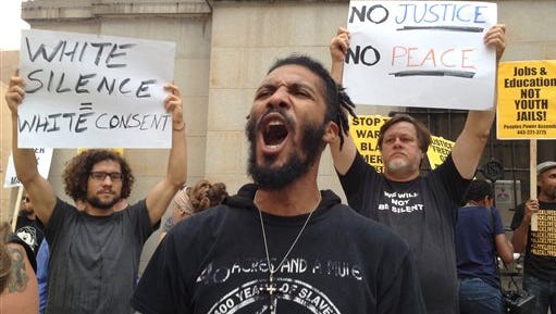 Protesters gather outside Baltimore Circuit Court, as the first court hearing was set to begin in the case of six police officers criminally charged in the death of Freddie Gray, on Wednesday, Sept. 2, 2015 in Baltimore.  Six police officers face charges that range from second-degree assault, a misdemeanor, to second-degree "depraved-heart" murder.   (Lloyd Fox/The Baltimore Sun via AP)  WASHINGTON EXAMINER OUT; MANDATORY CREDIT  
