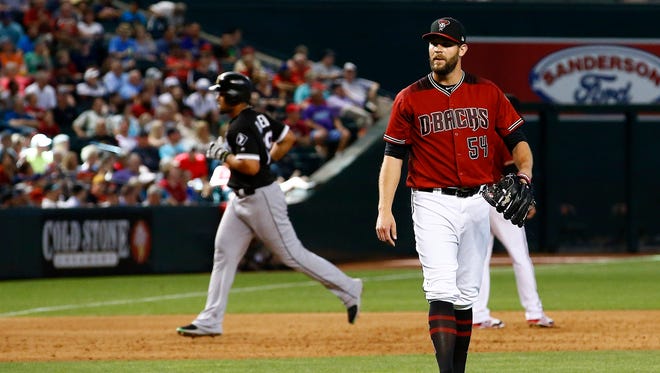Arizona Diamondbacks' Tom Wilhelmsen (54) waits for a new baseball after giving up a two-run home run to Chicago White Sox's Jose Abreu, left, during the sixth inning of a baseball game Wednesday, May 24, 2017, in Phoenix.
