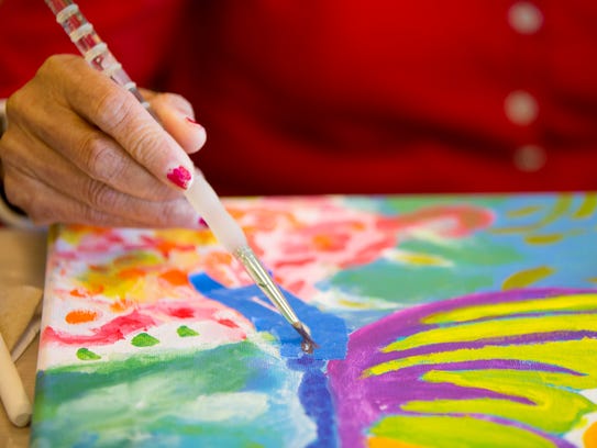 Maria Flores, 76, of El Mirage, takes a painting class