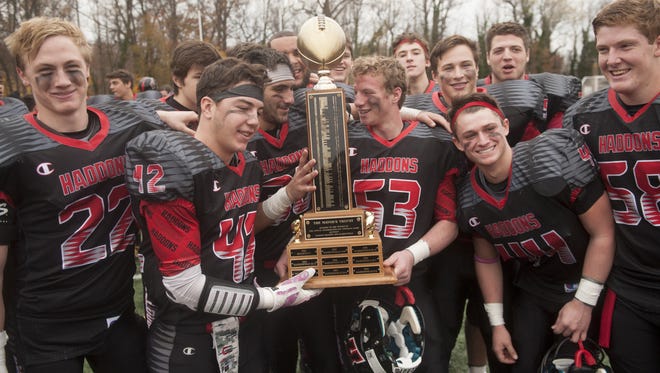 Members of the Haddonfield football team hold the Mayor's Trophy, which is awarded to the winner of the annual Thanksgiving Day football game between Haddon Heights and Haddonfield, after Haddonfield beat Haddon Heights on Thursday.