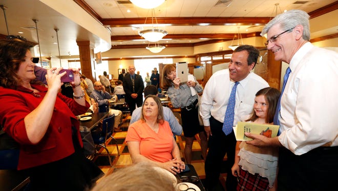 New Jersey Gov. Chris Christie, second from right, and Mississippi Gov. Phil Bryant, right, pose for a photograph with a young patron during a meet-and-greet Tuesday at a restaurant in Flowood.