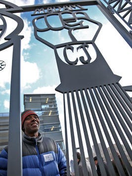 Artist Bernard Williams talks Dec. 18, 2015, at the unveiling of his artwork, the "Talking Wall, 2015" sculpture on the Indianapolis Cultural Trail at Indiana University-Purdue University Indianapolis. This is one of his favorite parts of the sculpture, a symbol of a Black Power fist on a hair pick, honoring Madam C.J. Walker, the first African-American female millionaire who made her money in the hair and beauty industry in Indianapolis.
