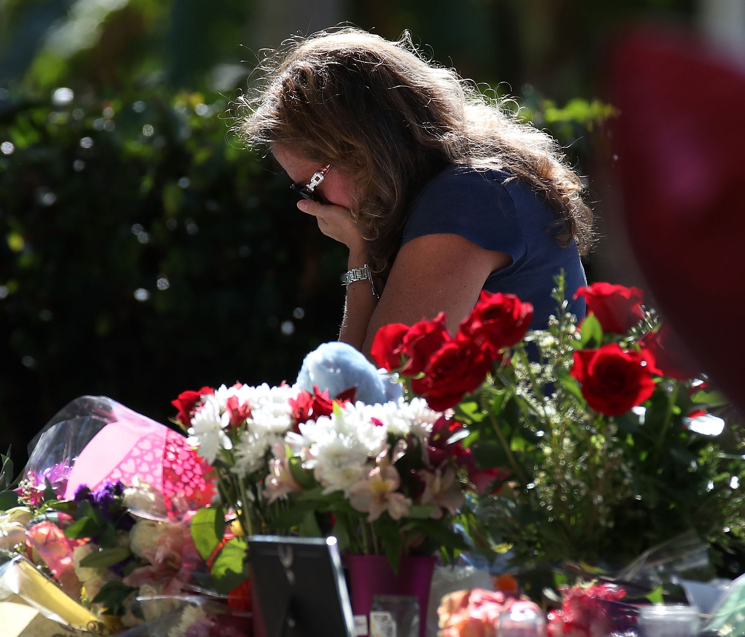 A woman becomes emotional while visiting a temporary memorial at Pine Trails Park on Feb. 17, 2018 in Parkland, Fla.