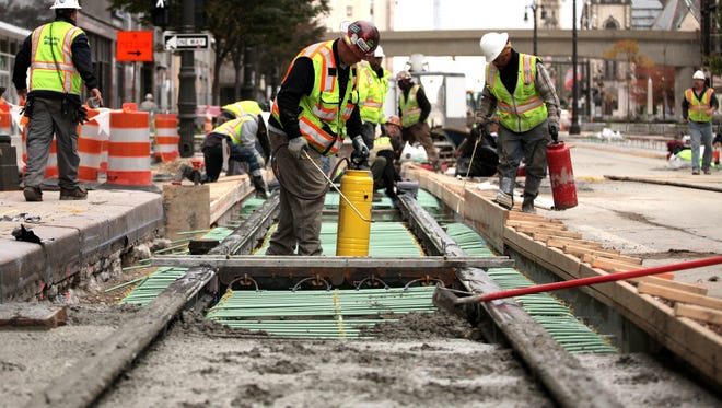The construction industry is trying to attract more young people to the field, which offers good pay for work as electricians, plumbers, carpenters, heavy-equipment opoerators, and more. Pictured are construction workers building Detroit's M-1 Rail streetcar line in November 2015.