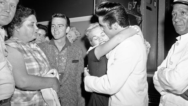 Anita Wood, 19, gets a hug from Elvis before he boards a train in Memphis on Aug. 29, 1957.