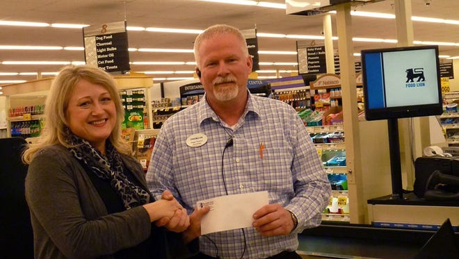 Pellissippi State Community College Service Learning Coordinator Annie Gray accepts grant funding from Food Lion representative Roger Scarbro.