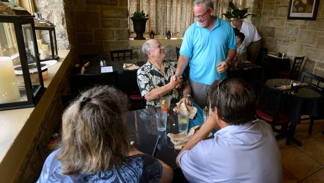 Paul Kilmartin,right, greets his friend Doug Lasater Sunday at The Vineyard in Old Sacred Heart Hospital in East Hill. Kilmartin faces an ethics complaint dating back to his time on the Milton City Council