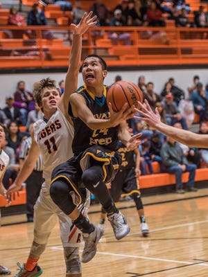 Navajo Prep's Thomas Montanez puts up a shot against Aztec's Cody Smith on Saturday at Lillywhite Gym in Aztec.