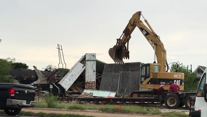 An excavator breaks down the walls of a long-closed Allsup's convenience store at 102 N. Pioneer Drive on Monday.
