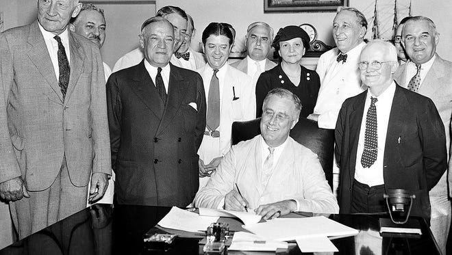 In this Aug. 14, 1935, file photo, President Franklin Roosevelt signs the Social Security Bill in Washington. The massive retirement and disability program is feeling its age. Social Security’s disability fund is projected to run dry next year. The retirement fund has enough money to pay full benefits until 2035.