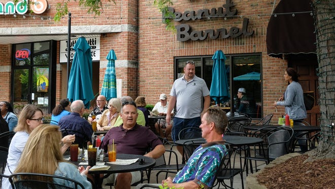 People enjoy the outdoor patio at The Peanut Barrel in East Lansing, Saturday, June 23, 2018. The popular restaurant/bar is beginning to switch from plastic utinsels and cups to compostable products. 