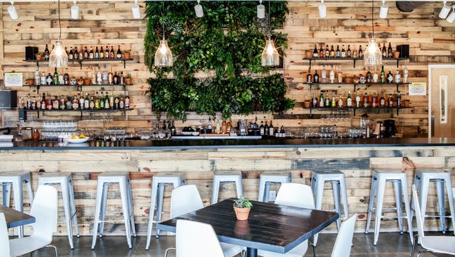 Behind the bar, between shelves of mindfully sourced booze, is the living wall, a vertical block of plants.
